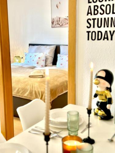 a table with two candles and a room with a bed at Wohnen direkt am Bregenzer Hafen in Bregenz