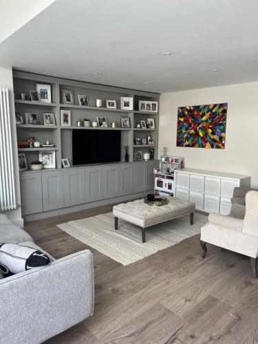 a living room with a couch and a tv at Luxury 4 Bedroom Home, South Dublin in Blackrock