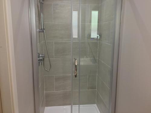 a shower with a glass door with a shower at Seacroft in Kirkton