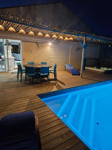 un patio avec une table et des chaises et une piscine dans l'établissement La Villa des Lions, au Grau-dʼAgde