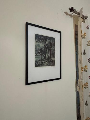 a picture hanging on a wall in a room at Hoglabon nest in kolkata