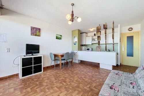un salon avec une cuisine et une salle à manger dans l'établissement Charming T2 with terrace on the seafront, à Port-la-Nouvelle