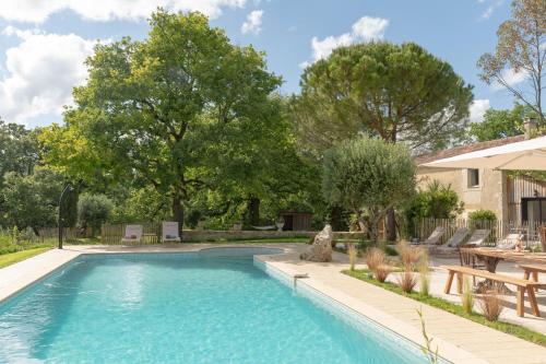 a swimming pool with a picnic table and trees at Le Mas Gascon - Maison de vacances 4 étoiles avec piscine et vue proche de Lectoure in Marsolan