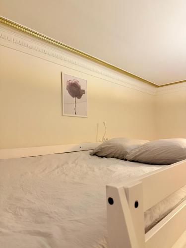 une chambre avec un lit dans une pièce blanche dans l'établissement Appartement hausmanien élégant dans le 6ème, à Paris