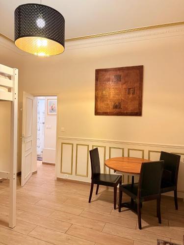 une salle à manger avec une table et des chaises dans l'établissement Appartement hausmanien élégant dans le 6ème, à Paris
