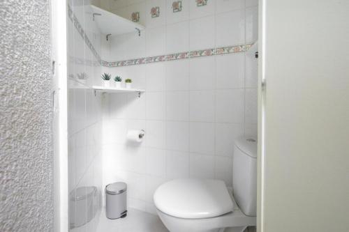 une salle de bain blanche avec des toilettes et un lavabo dans l'établissement Appartement hausmanien élégant dans le 6ème, à Paris