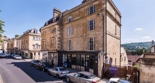a building with cars parked on the side of a street at Vintner Townhouse Artisan Quarter Bath in Bath