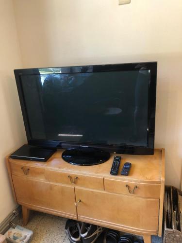 a flat screen tv sitting on top of a wooden dresser at Charmant vakantiehuis aan de Ourthe in Maboge La Roche en Ardenne in La Roche-en-Ardenne