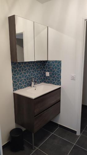 une salle de bain avec un lavabo et un miroir dans l'établissement Gîte Les Aravis, à Passy