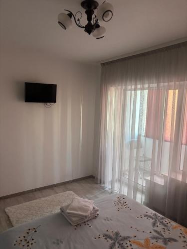 a bedroom with a bed and a tv on the wall at Apartament SUN Drăgășani in Drăgăşani