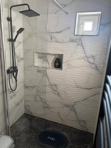 a shower with a glass door in a bathroom at Apartament SUN Drăgășani in Drăgăşani
