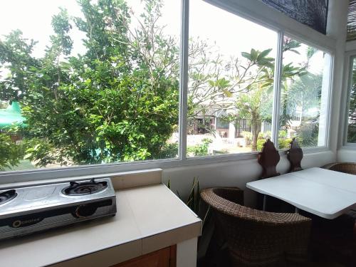 a kitchen with a stove and two windows at Casa de Arte in Boracay