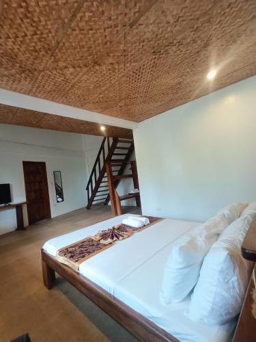 a large bed in a room with a wooden ceiling at Casa de Arte in Boracay