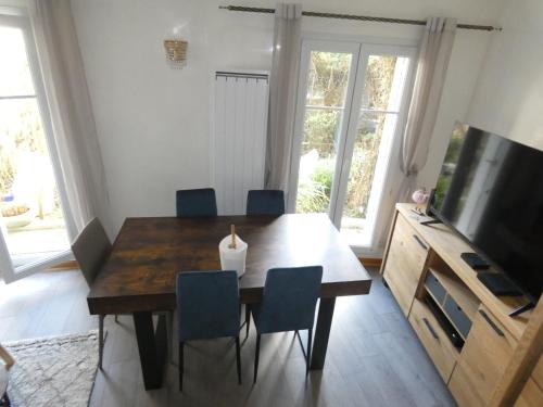 a dining room table with chairs and a television at Appartement spacieux et 5 minutes DISNEY LAND PARIS in Bailly-Romainvilliers