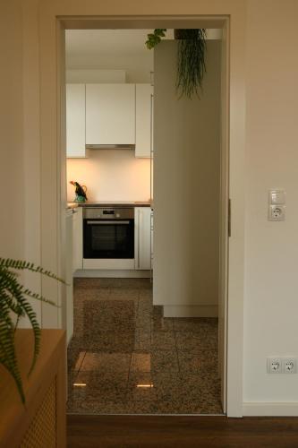 a kitchen with white cabinets and a black oven at Engel Apartments in Hard