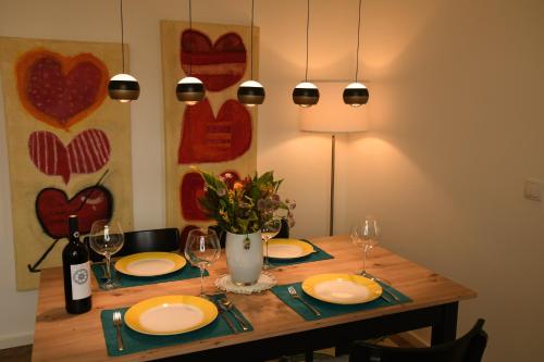 a dining room table with plates and wine glasses at Engel Apartments in Hard