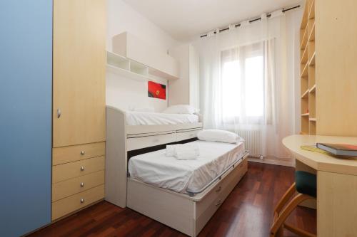 a small bedroom with two bunk beds and a desk at Modena Visit Apartment in Modena