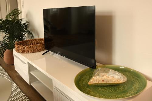 a flat screen tv sitting on top of a white cabinet at Engel Apartments in Hard