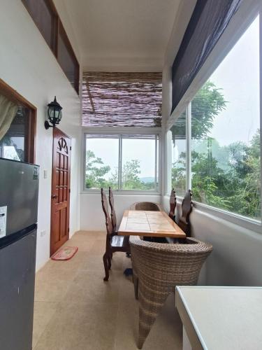 a dining room with a table and a large window at Casa de Arte in Boracay