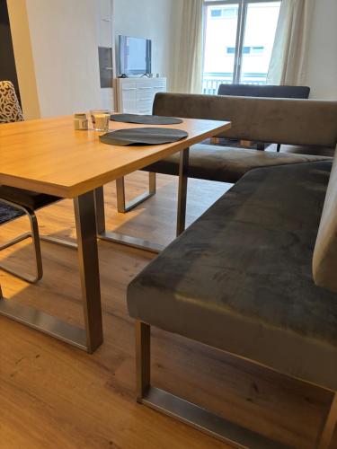 a wooden table and a couch in a living room at Moderne Wohnung in Linz