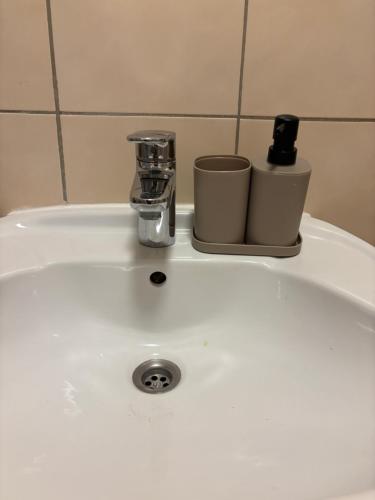 Un lavabo con un grifo y dos tazas. en Moderne Wohnung, en Linz
