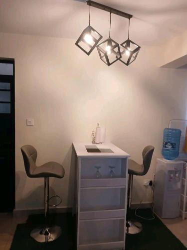 a room with two chairs and a desk and lights at Charity homes in Ruiru