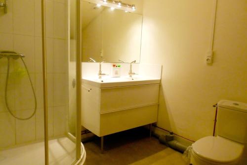 une salle de bain avec un lavabo, une douche et des toilettes dans l'établissement Dans la cours du château by Miss K, à Chaintré