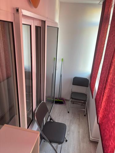 a small room with two chairs and a window at Apartament SUN Drăgășani in Drăgăşani