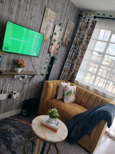 a living room with a couch and a flat screen tv at Charity homes in Ruiru