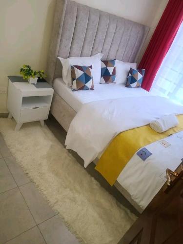 a bedroom with a large bed and a night stand at Charity homes in Ruiru