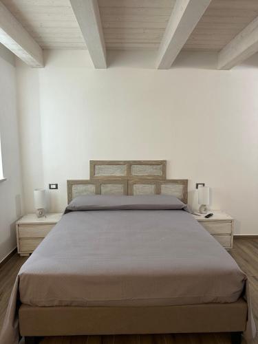 a bed in a white room with two night stands at La Casetta della Nonna in Belmonte Calabro