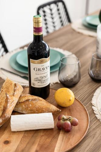 - une bouteille de vin assise sur une table en bois avec de la nourriture dans l'établissement Suite Sérénade - Appartement à Cannes, à Cannes