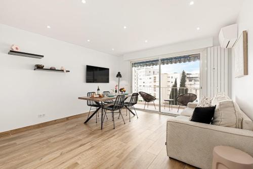 un salon blanc avec une table et un canapé dans l'établissement Suite Sérénade - Appartement à Cannes, à Cannes