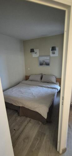 a bed in a bedroom with two lights above it at Appartement avec Vue Cap d'Antibes in Vallauris