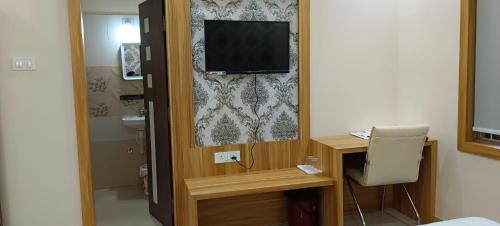 a room with a television and a desk with a chair at Palm Tree Haven in Bhubaneshwar