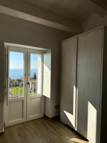 an empty room with a door and a window at La Casetta della Nonna in Belmonte Calabro