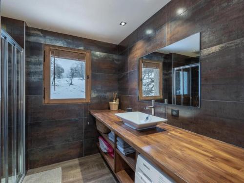 une salle de bain avec un lavabo et un miroir dans l'établissement Chalet Jeane proche du Centre ville de Megève, à Megève