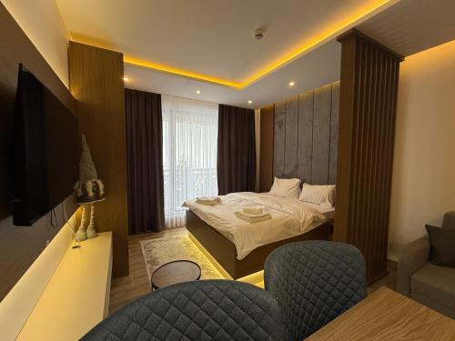 a hotel room with a bed and a couch and chairs at Fashion Residence Hill in Kopaonik