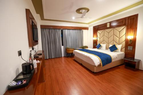 a bedroom with a king sized bed and a desk at Hotel Chhutuk Heights in Kargil