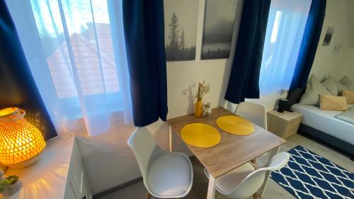 a living room with a table and chairs and a couch at Oázis Apartmanház Balatonalmádi in Balatonalmádi