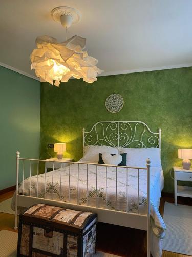 a bedroom with a bed and a chandelier at Los Kukos Casa Rural in Riaño