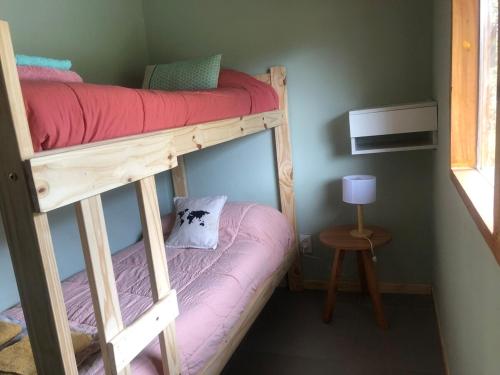 ein Schlafzimmer mit zwei Etagenbetten und einem Tisch in der Unterkunft Casa con magnifica vista al Cerro Catedral in San Carlos de Bariloche