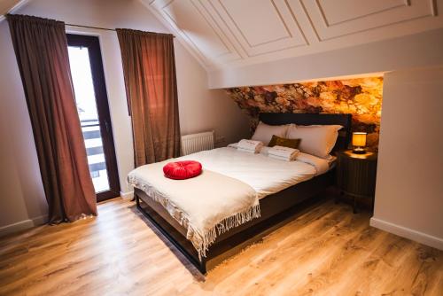a bedroom with a bed with red pillows on it at The Vardo - Elegant Villa in Predelut in Bran