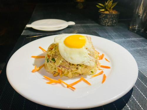 a plate of food with an egg on top at Wild Blossom Sigiriya in Sigiriya