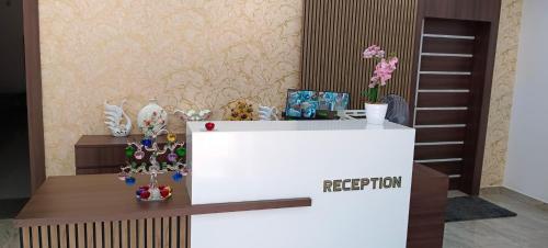 a reception desk with vases and flowers on it at Palm Tree Haven in Bhubaneshwar