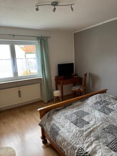 a bedroom with a bed and a desk with a computer at Ferienwohnung Aurach in Aurach