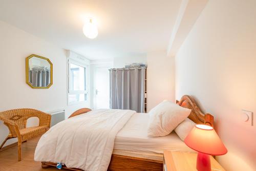 une chambre avec un lit et une table avec une lampe dans l'établissement APPARTEMENT AU PIED DE LA PLAGE trestraou, à Perros-Guirec