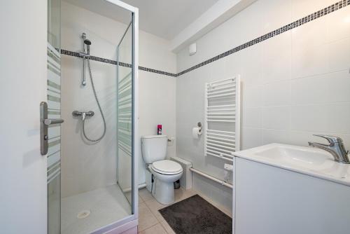 une salle de bain avec toilettes, lavabo et douche dans l'établissement APPARTEMENT AU PIED DE LA PLAGE trestraou, à Perros-Guirec