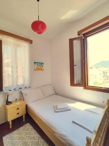 a small bedroom with a bed and a window at Lovely 2-bedroom with panoramic view in Skopelos Town