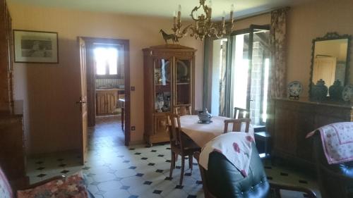 a dining room with a table and chairs and a chandelier at Maison récente type traditionnelle 9 couchages in Trizac